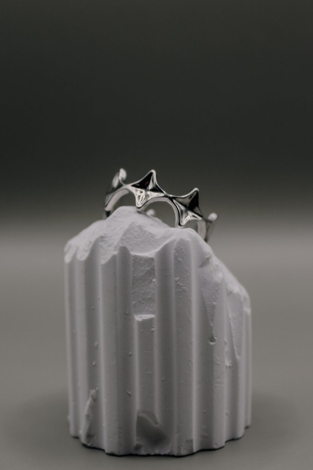 Silver ring on a textured white object against a dark background