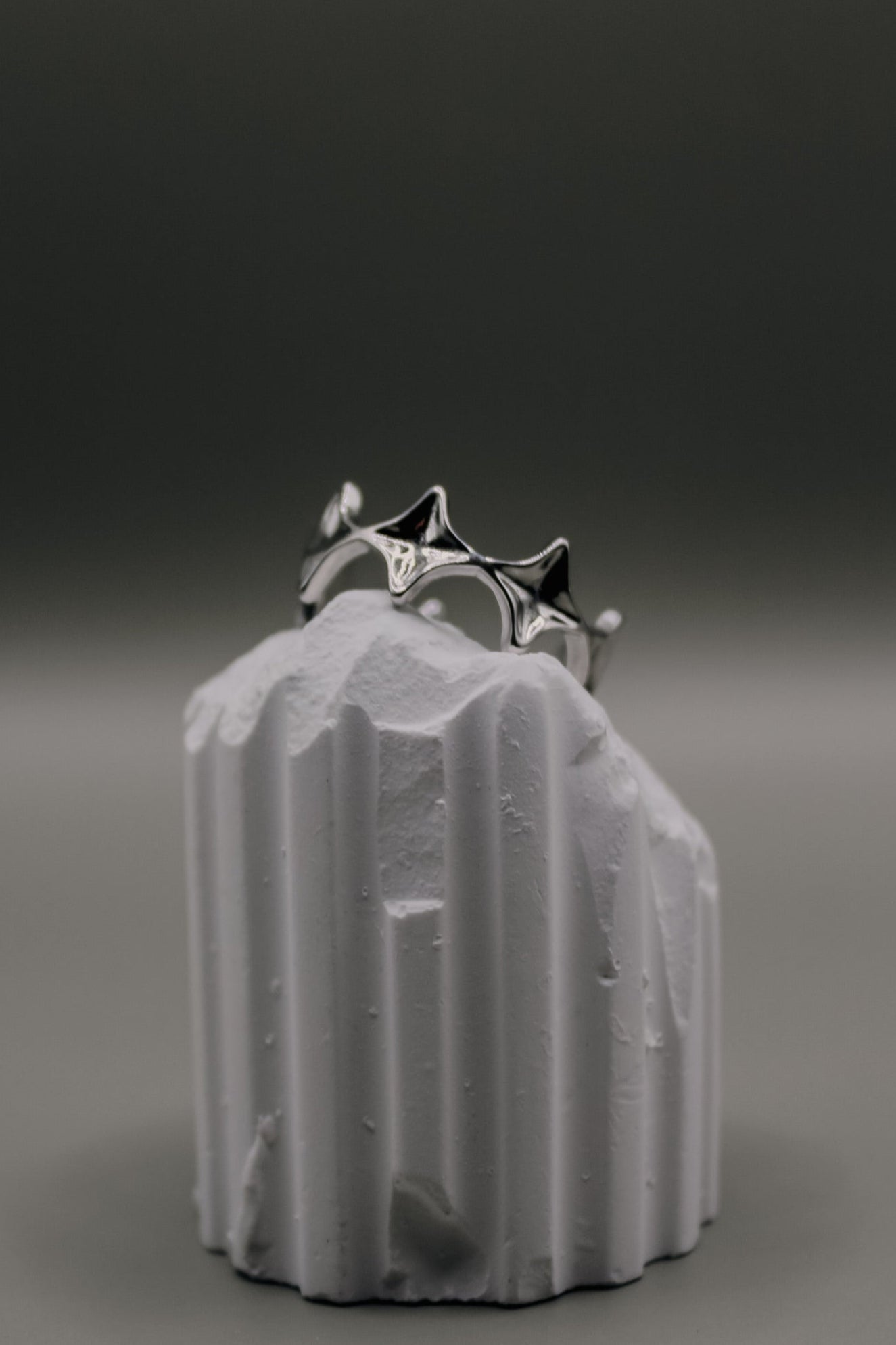 Silver ring on a textured white object against a dark background